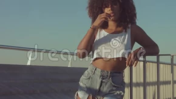 户外混合种族黑人女青年夏季日落光线巴塞罗那海滩地带视频的预览图