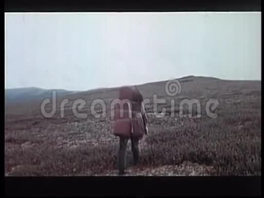带大背包徒步穿越山区的人的后景视频的预览图