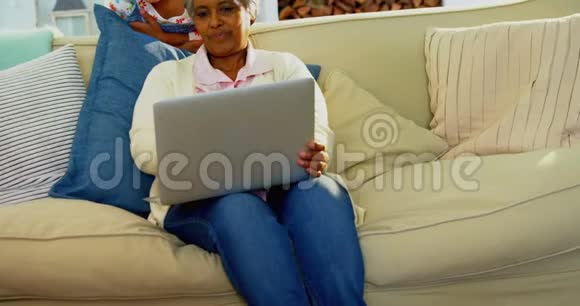 祖母和孙女在4k客厅用笔记本电脑视频的预览图