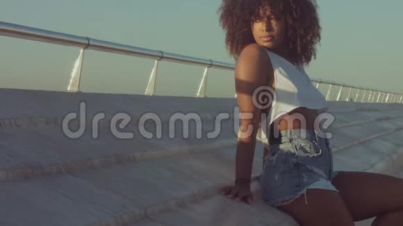 户外混合种族黑人女青年夏季日落光线巴塞罗那海滩地带视频的预览图