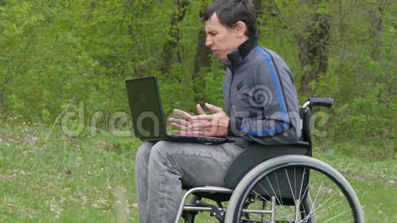 一个残疾人一个愤怒的男人一个大喊商人老板一个问题视频聊天轮椅笔记本电脑视频的预览图