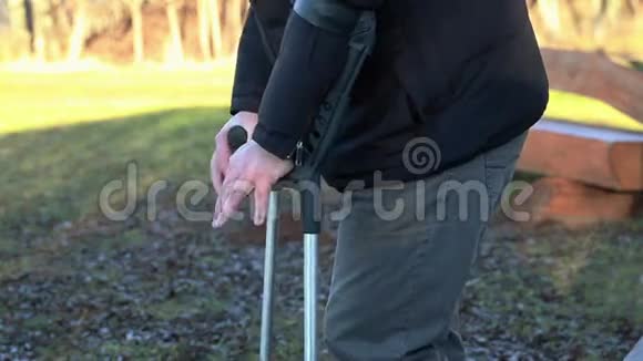 残疾人拄着拐杖在户外长椅旁视频的预览图