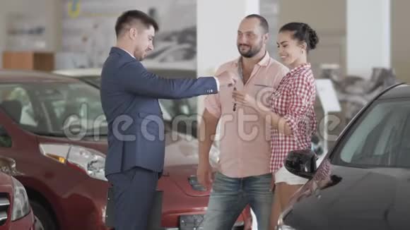 在汽车经销商和年轻夫妇之间成功的交易视频的预览图