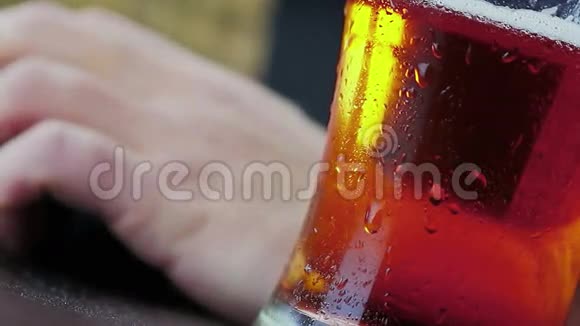 男人在鼠标和电脑键盘前喝泡沫啤酒视频的预览图