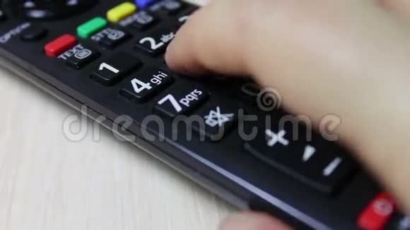 人的手改变电视遥控器上的频道视频的预览图