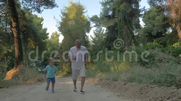 祖父和孙子在森林里慢跑视频的预览图