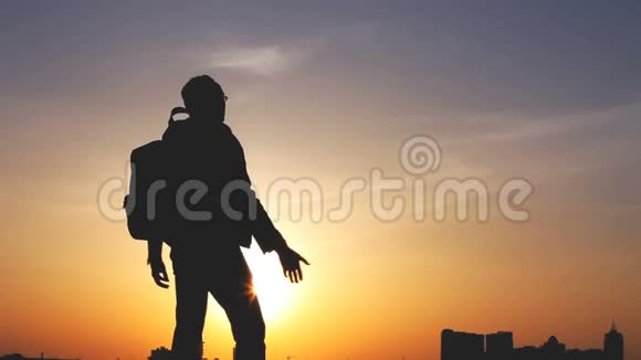一个背着背包的男人在明亮的天空中的剪影视频的预览图
