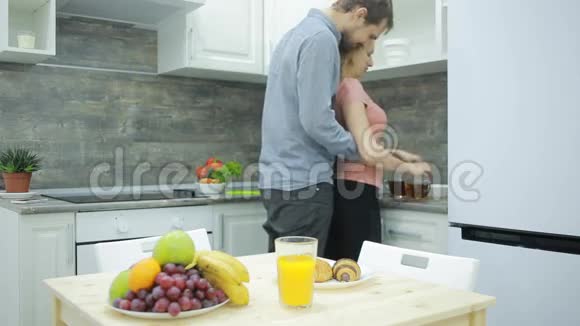 厨房里的年轻夫妇喝茶吃水果视频的预览图