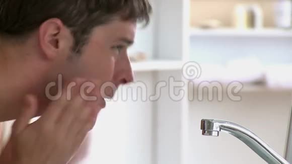 自信的男人在家里的浴室里刮胡子视频的预览图
