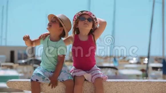 小男孩小女孩坐在码头上视频的预览图
