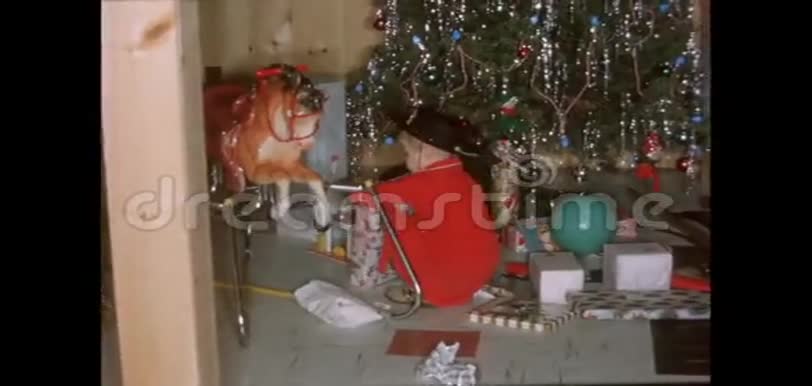 小男孩在圣诞树下打开礼物视频的预览图