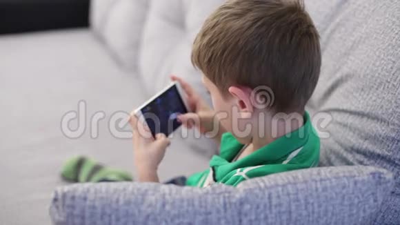 小男孩在智能手机上玩视频的预览图