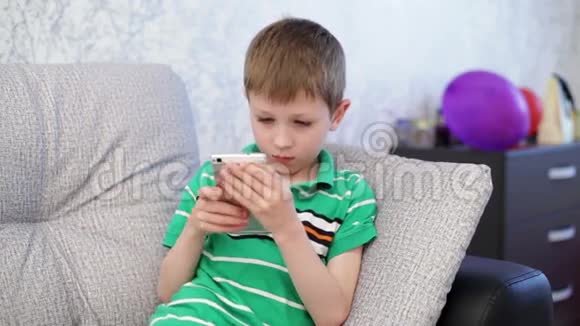 小男孩在智能手机上玩视频的预览图