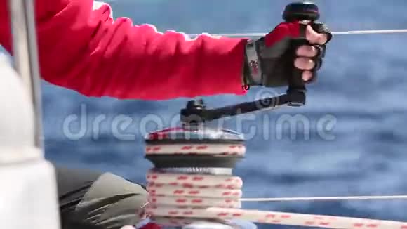 双手拉绳缠绕床单缠绕绞车特写水手的手在帆船的绞车上视频的预览图