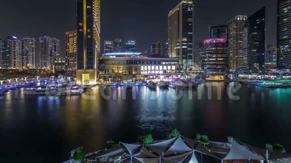 迪拜码头的空中蔬菜与购物中心餐厅塔楼和游艇夜间时间推移阿拉伯联合酋长国视频的预览图