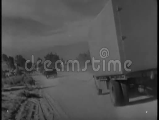 一辆汽车和卡车在土路上行驶的后景视频的预览图