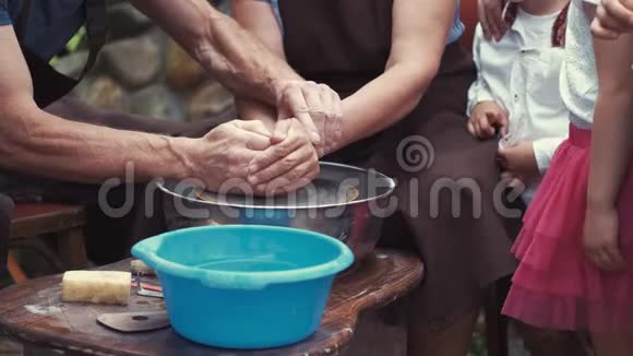 带着孙子孙女的祖父母用陶器制作水壶视频的预览图