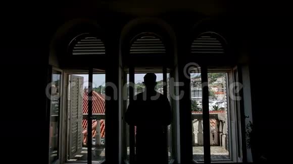 一个男人在阳台上穿夹克的剪影视频的预览图