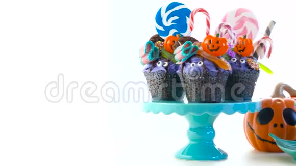 万圣节糖果滴蛋糕风格的纸杯蛋糕与棒棒糖和糖果白色视频的预览图