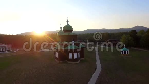 在阳光明媚的夏日傍晚在田野上教堂俄罗斯布里亚蒂亚乌兰乌德的鸟瞰图视频的预览图