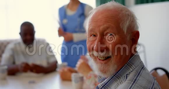 活跃的高加索老人坐在疗养院的侧视4k视频的预览图