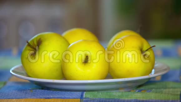 黄苹果躺在桌子上的盘子里视频的预览图