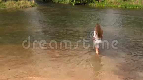 漂亮的白人少女穿着灰色衣服站在河里视频的预览图