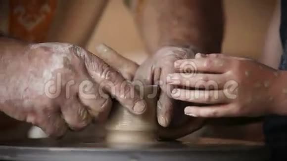 年老的陶工和年轻的学生的手视频的预览图