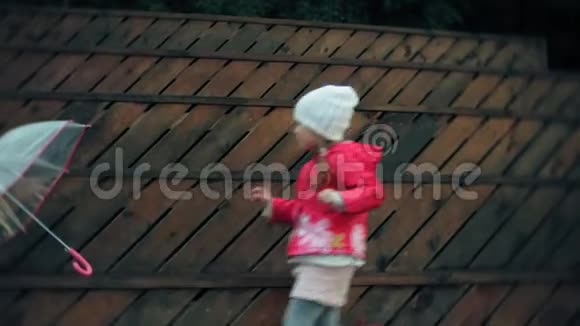 小女孩和妈妈带着雨伞在雨中玩耍视频的预览图