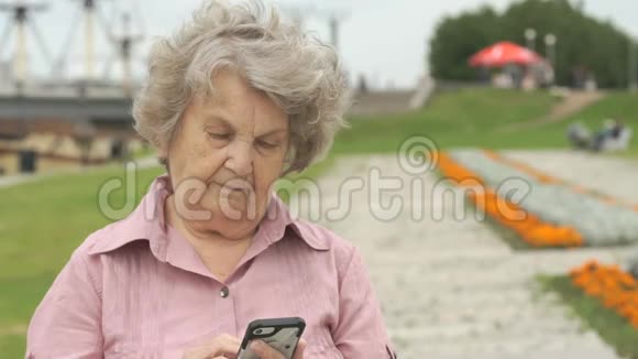 微笑成熟的老妇人拿着智能手机视频的预览图