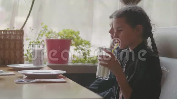 两个可爱的孩子一起喝奶昔或调味饮料室内慢动作视频咖啡馆快餐男孩和女孩视频的预览图