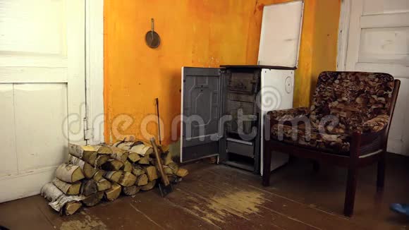 女人把木头带到房间里把堆放在炉子旁边家务活视频的预览图