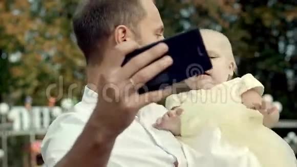 有宝宝的家庭在公园用手机自拍视频的预览图