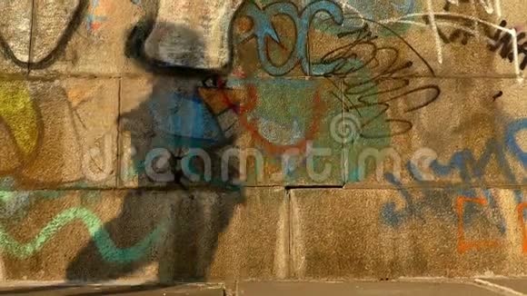 日落时分一个男人在墙上涂鸦的滑稽的舞蹈影子在邋遢的黄昏视频的预览图