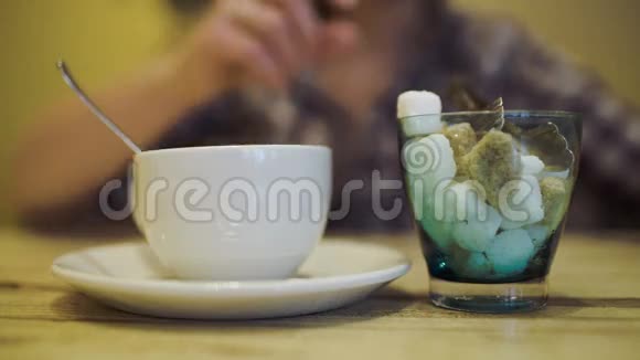 女人用钳子把糖放进茶杯里视频的预览图