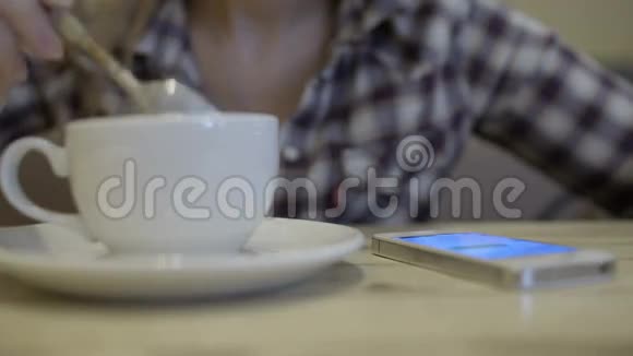 女人搅拌咖啡打短信视频的预览图