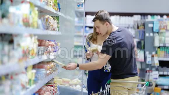 一对情侣在超市里买手推车视频的预览图