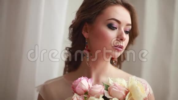 身着粉色婚纱的女孩正坐在一间漂亮的房间里周围是鲜花和蜡烛视频的预览图