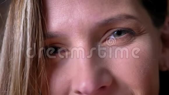 一双美丽的成年女性灰色眼睛用微笑的面部表情直视镜头视频的预览图