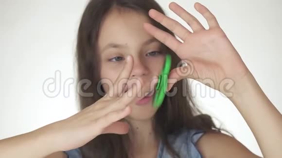 美丽开朗的女孩在白色背景的股票视频中玩绿色烦躁的旋转视频的预览图