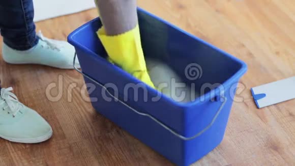 女人在家里用桶里的破布清洗和挤压视频的预览图
