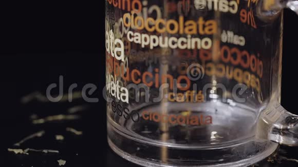 在玻璃杯中加入干茶叶准备绿茶慢动作黑色背景视频的预览图