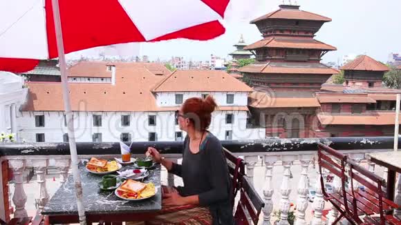 美丽的高加索女孩吃早餐午餐在屋顶加德满都尼泊尔视频的预览图