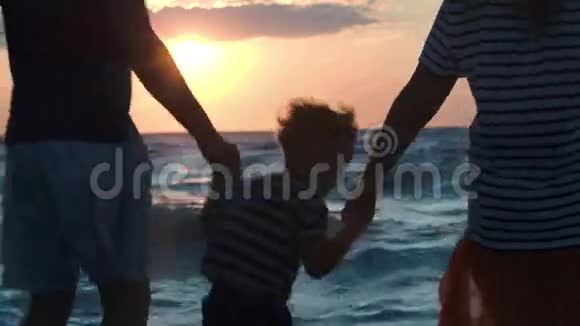 日落时分三个幸福的家庭在海上跳舞视频的预览图