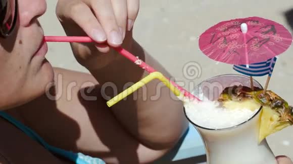 在海滩上喝鸡尾酒享受夏日的女人视频的预览图