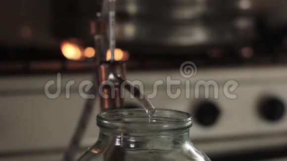 家生产的酒精上的火焰酒精蒸馏设备液体流入玻璃罐视频的预览图