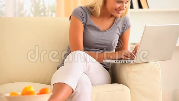 女人躺在沙发上搜索网络视频的预览图