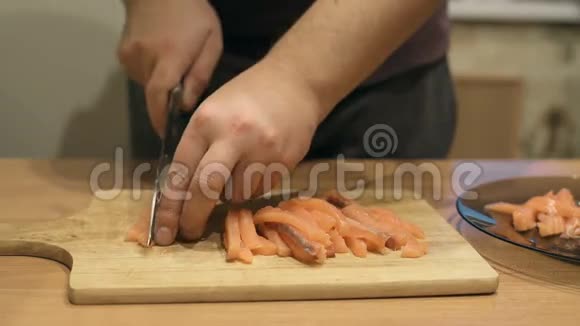 厨师切三文鱼切三文鱼刀切鱼三文鱼厨师站在寿司吧的厨房里视频的预览图