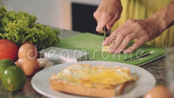 在厨房桌子上切软奶酪做三明治女人的手视频的预览图