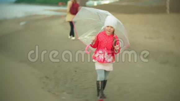 小女孩和妈妈带着雨伞在雨中玩耍视频的预览图